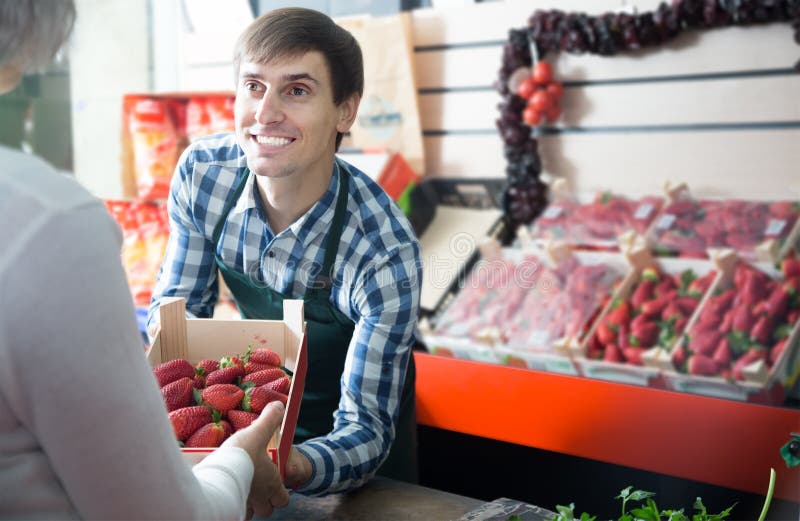 Young kindly grocery worker at local market