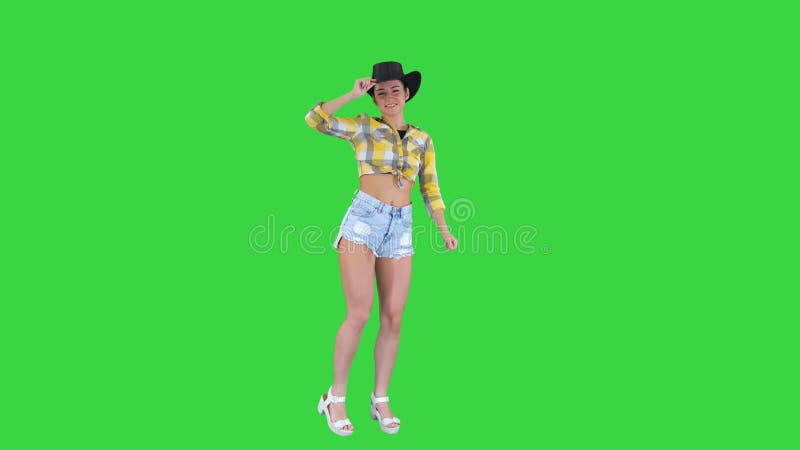 Young lady in a cowboy hat dancing on a Green Screen, Chroma Key.