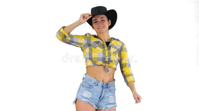 Young lady in a cowboy hat dancing on white background.