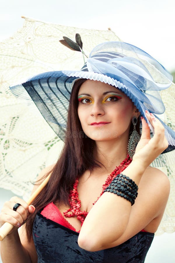Portrait of an young lady in blue hat with an umbrella. Bright red hat stock images, royalty-free photos and pictures