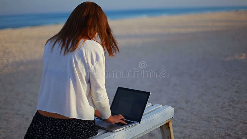 Young lady working with a text editor during vacation at the seaside stock footage