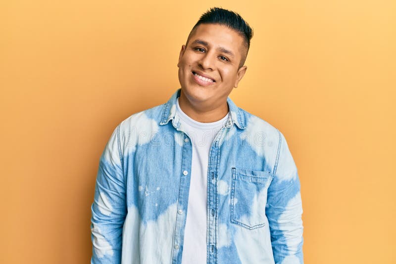 Young latin man wearing casual clothes with a happy and cool smile on face