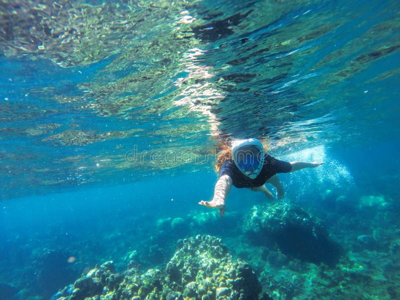 Young loose hair woman snorkeling in blue mask in coral reef stock photos Young loose hair woman snorkeling in blue mask in coral reef stock photos
