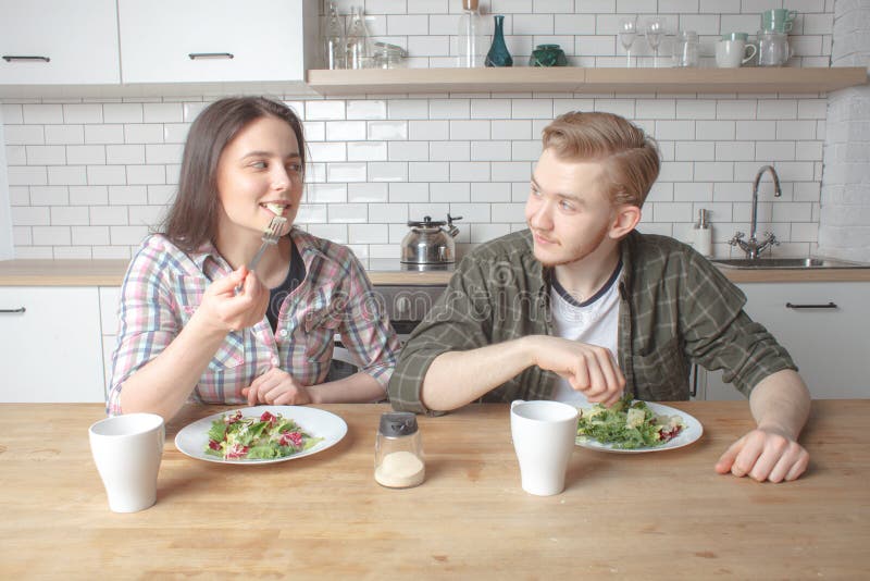Young lovely couple has breakfast at kitchen stock photos Young lovely couple has breakfast at kitchen stock photos