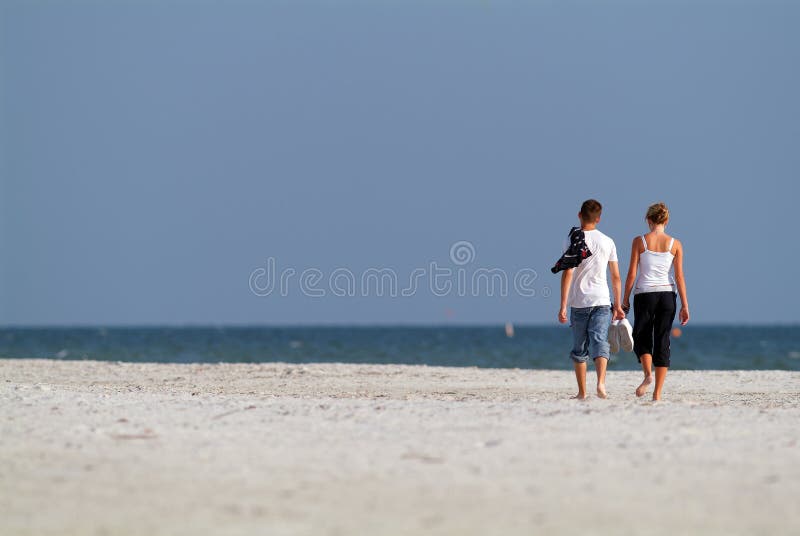 Joven amantes abajo Playa sobre el soleado por la tarde.