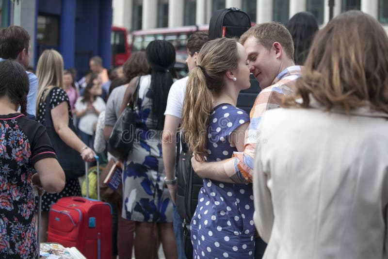 Young loving couple embracing and kissing at rush hour near the metro Covent Garden