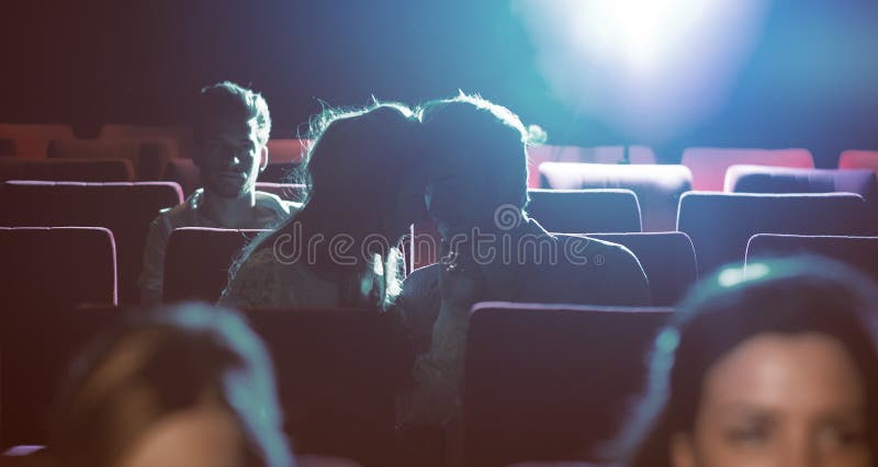 Young loving couple kissing at the cinema stock photography Young loving couple kissing at the cinema stock photography