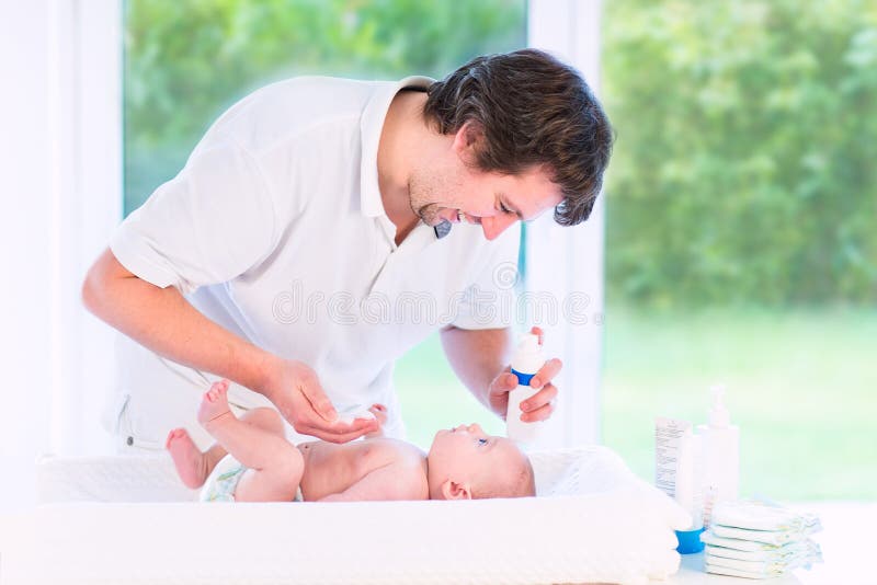 Young loving father changing diaper of newborn son royalty free stock photography Young loving father changing diaper of newborn son royalty free stock photography