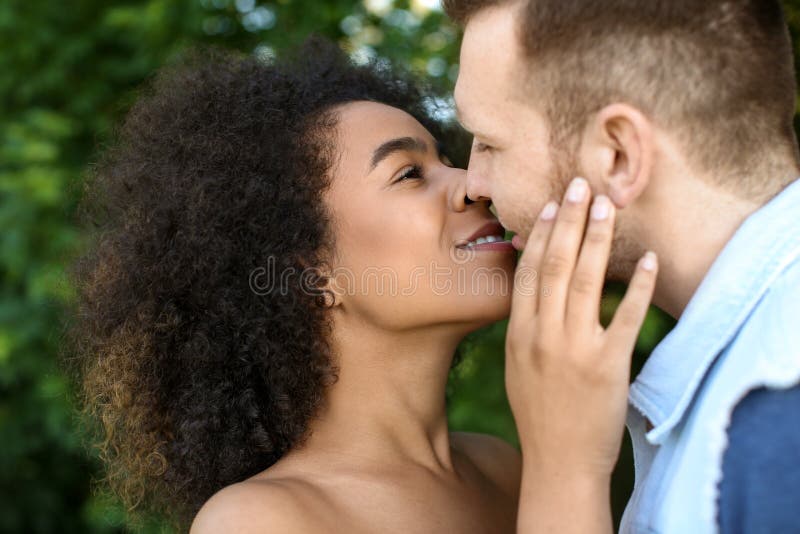 Young loving interracial couple kissing outdoors on spring day royalty free stock photography Young loving interracial couple kissing outdoors on spring day royalty free stock photography