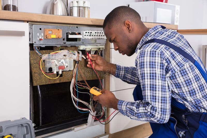 Technician Fixing Dishwasher With Digital Multimeter stock photography