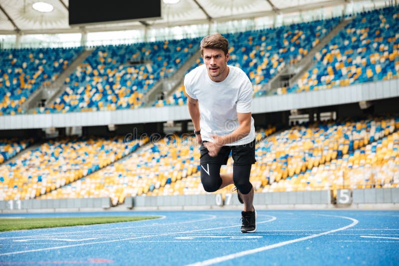 Young male athlete running on a racetrack stock images