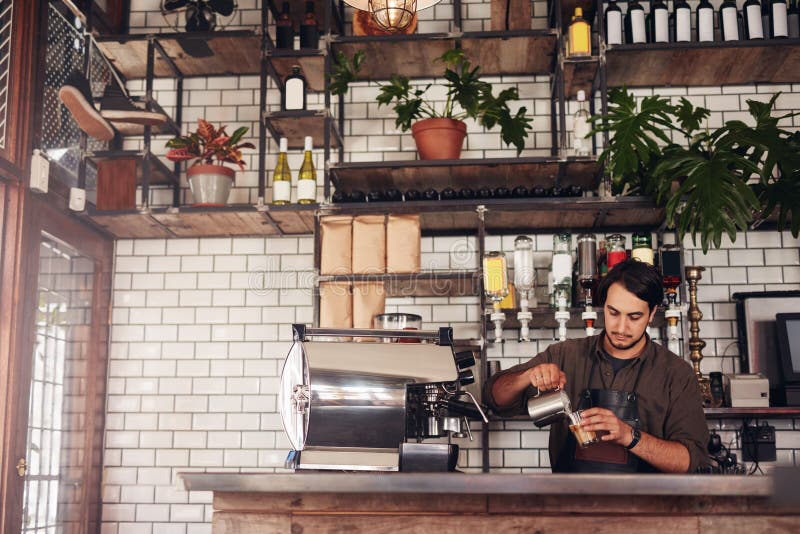 Young male barista making a cup of coffee royalty free stock image Young male barista making a cup of coffee royalty free stock image