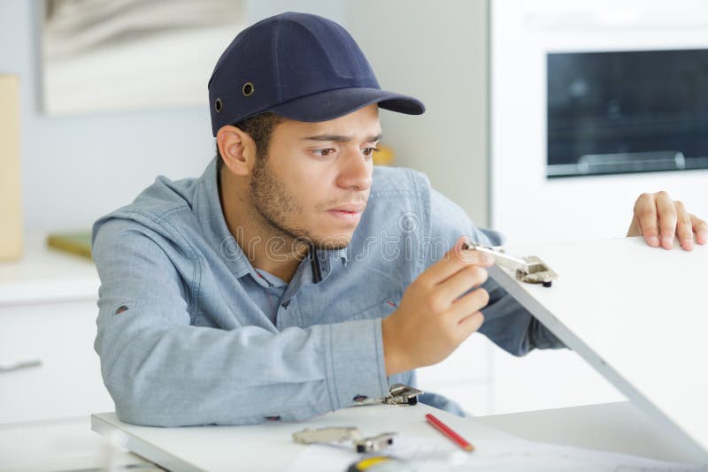 Young male contractor assembling fitted kitchen stock photo Young male contractor assembling fitted kitchen stock photo