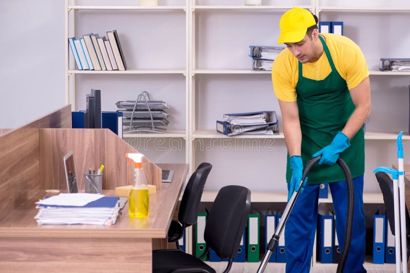 Young male contractor cleaning the office stock images Young male contractor cleaning the office stock images