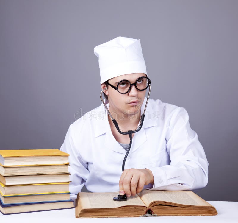 Young male doctor studying medical books