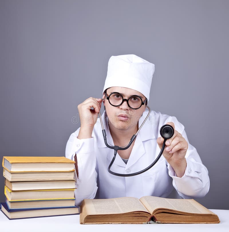 Young male doctor studying medical books