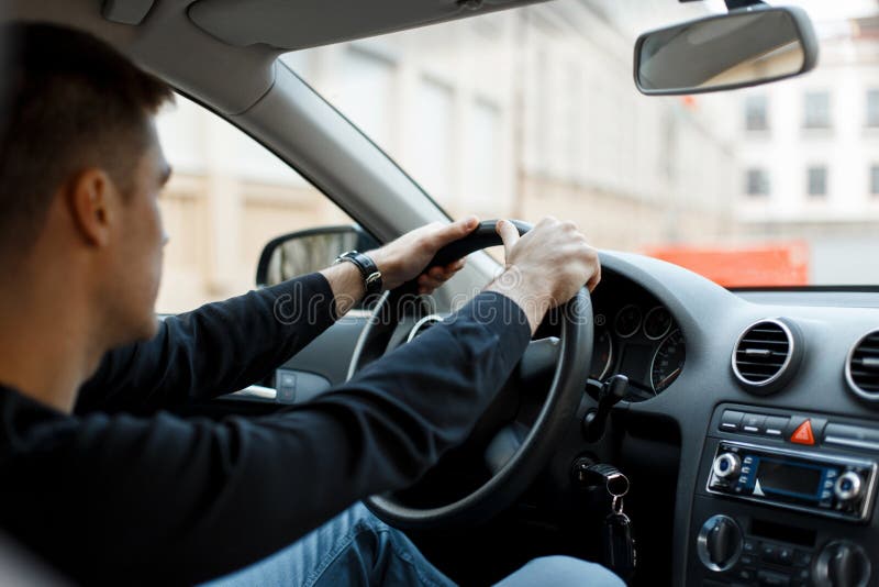 Young male driver sitting in the car and holding the wheel. royalty free stock photo Young male driver sitting in the car and holding the wheel. royalty free stock photo