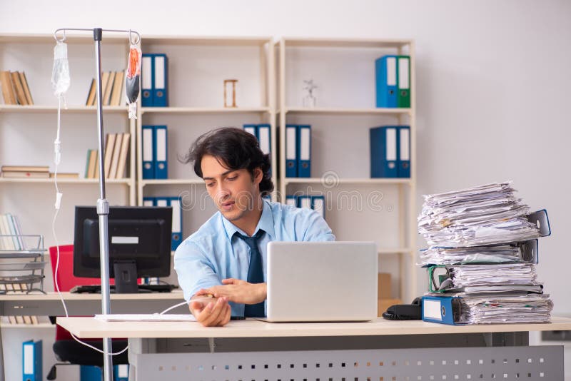 Young male employee in blood transfusion concept stock image Young male employee in blood transfusion concept stock image