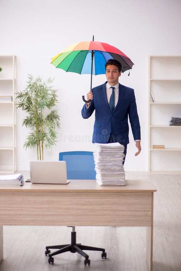 Young Male Employee Holding an Umbrella in the Office Stock Image