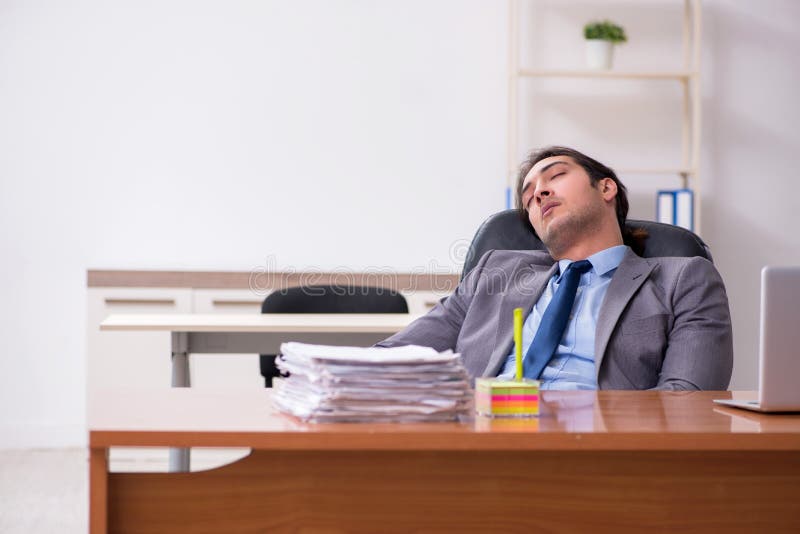 Young male employee sleeping in the office. Young employee sleeping in the office