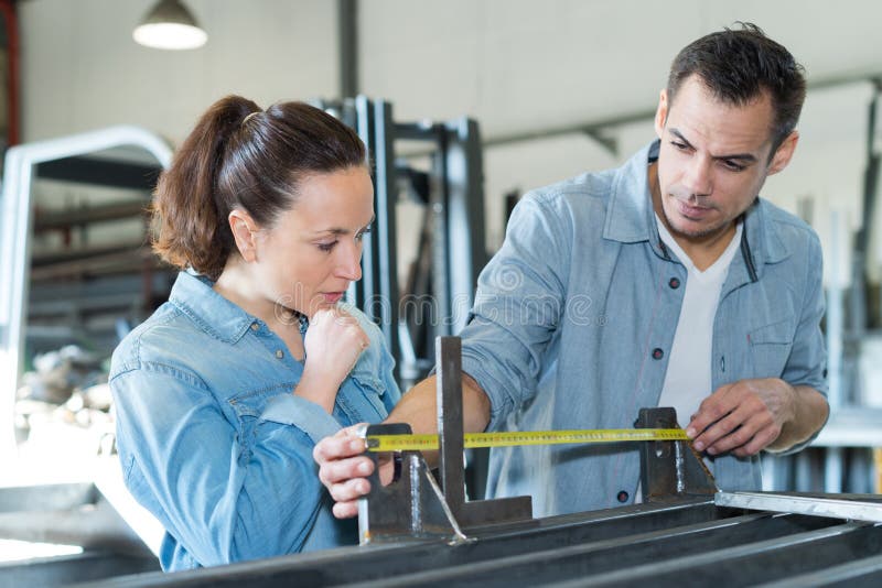 Young male and female workers measuring wood in workshop royalty free stock photos Young male and female workers measuring wood in workshop royalty free stock photos