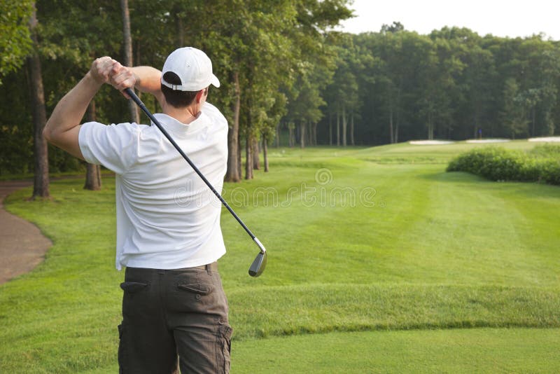 Young male golfer tees off on a par three