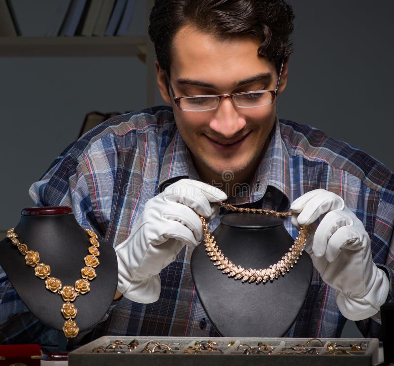 Young Male Jeweller Working at Night in His Stock Photo