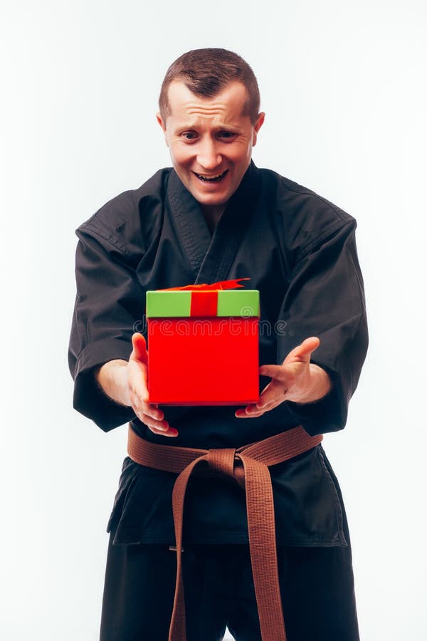 Young male with orange belt karate fighter training with gift box