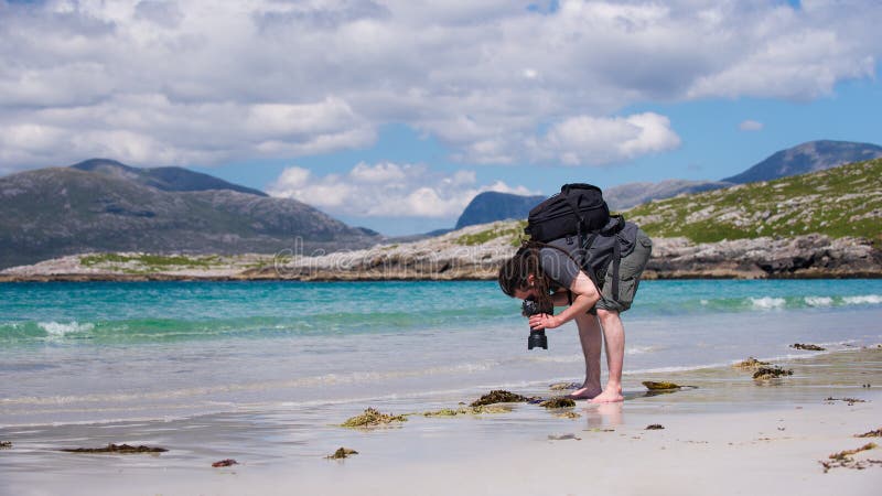 Young male photographer with dreadlocks at a sunny white sand beach, royalty free stock photo Young male photographer with dreadlocks at a sunny white sand beach, royalty free stock photo