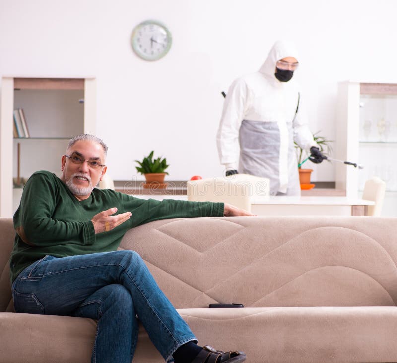 Young male sanitizer and old man indoors stock images