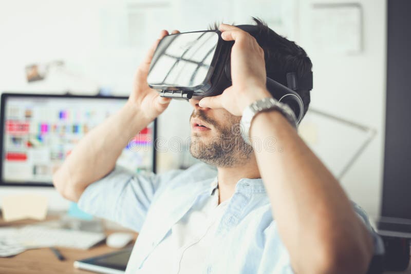 Young male software programmer testing a new app with 3d virtual reality glasses in office. stock photos Young male software programmer testing a new app with 3d virtual reality glasses in office. stock photos