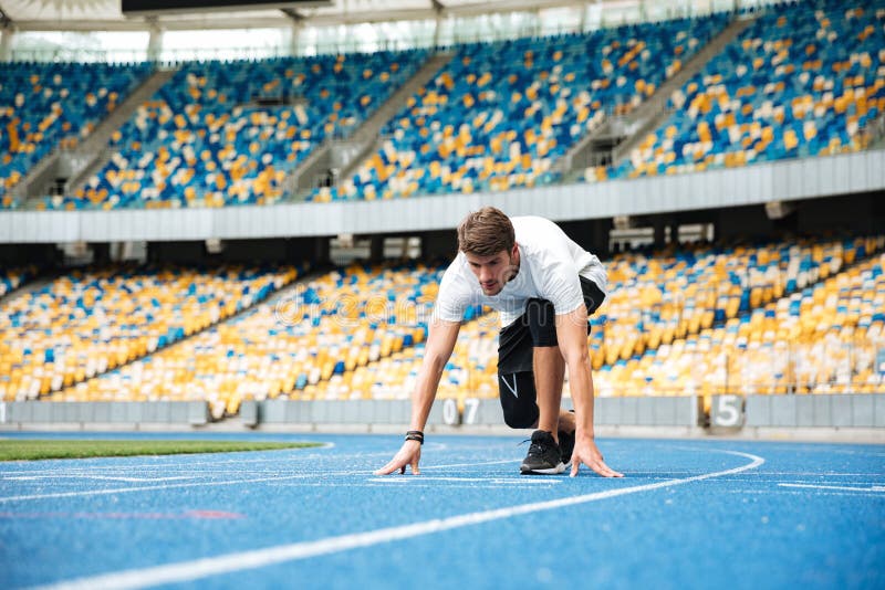 Young male sprinter about to start a race stock photo