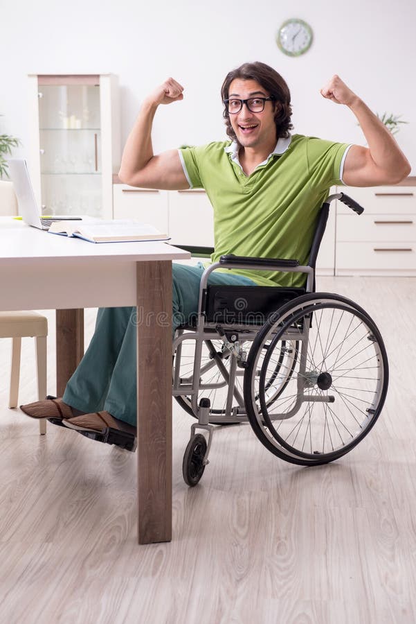 Young male student in wheelchair at home stock photo Young male student in wheelchair at home stock photo