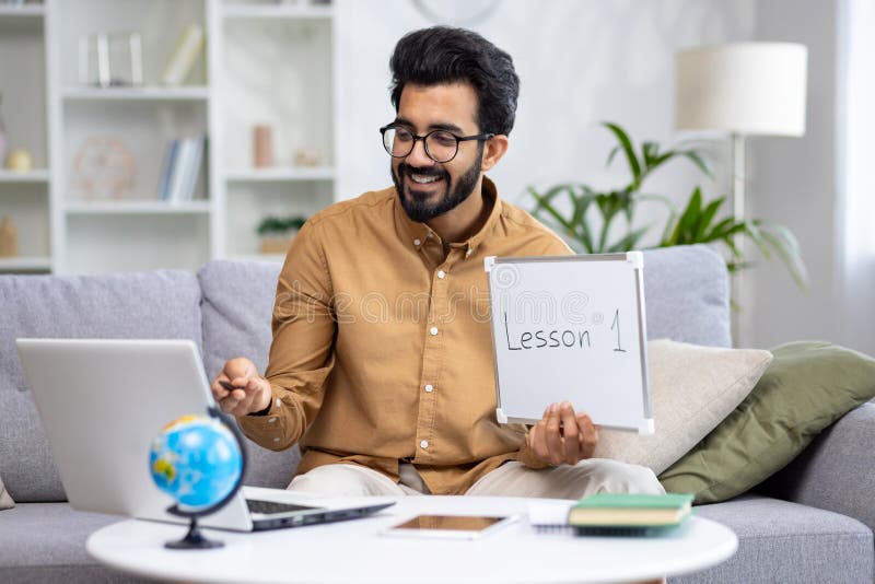 Young male teacher teaching remotely from home, hispanic using laptop for video call and communication and teaching royalty free stock photos