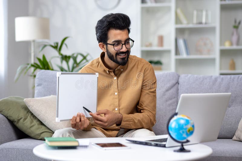 Young male teacher teaching remotely from home, hispanic using laptop for video call and communication and teaching stock images
