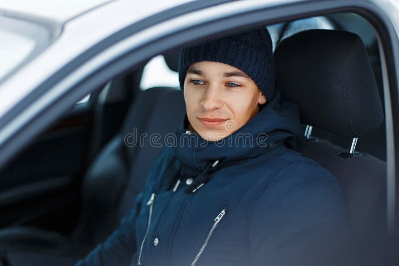 Young male in winter clothing sitting in a car stock photos Young male in winter clothing sitting in a car stock photos