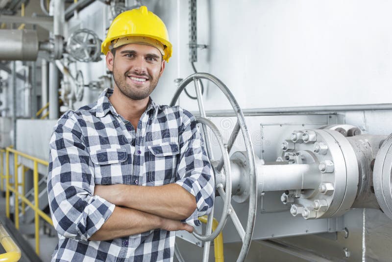 Young male worker standing arms crossed in industry stock images
