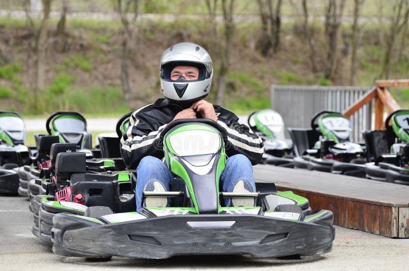 Young Man adjust helmet on Go-Kart Car on A Playground Racing Track stock photo