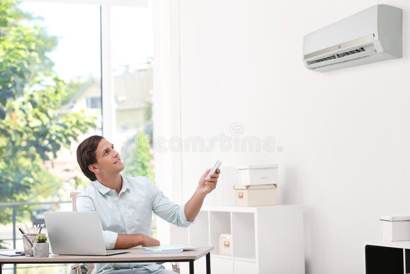 Young Man with Air Conditioner Remote in Office Stock Photo - Image of  office, modern: 136836810