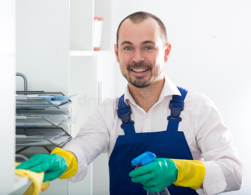 Young Man in Apron Cleaning Shelves Stock Image - Image of head, light ...