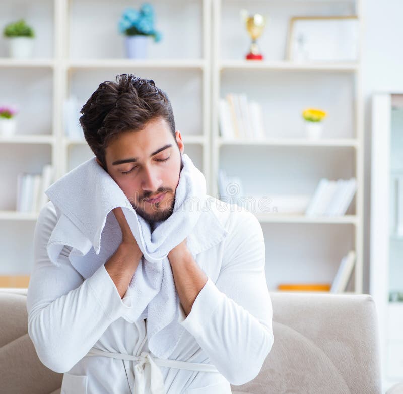 The Young Man Drying Hair at Home with a Hair Dryer Blower Stock Image