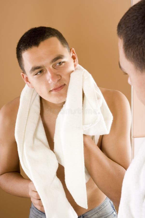 Young man in the bathroom s mirror after shaving