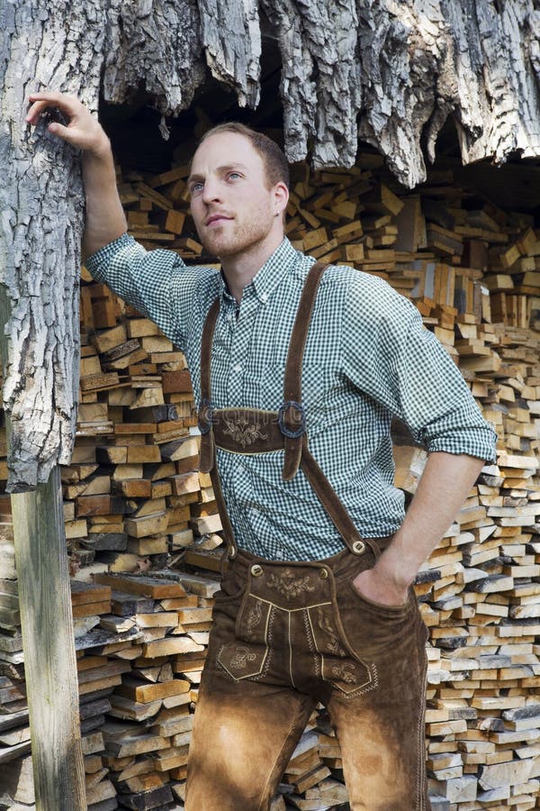 Young Man in Bavarian Lederhosen in Front of Firewood Stock Photo ...