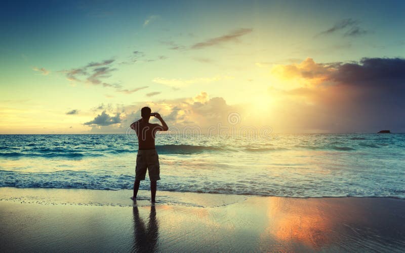 Young man on the beach take photo