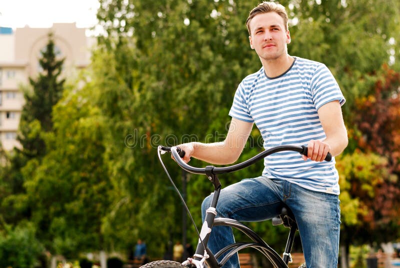 A young man on a bicycle looks into the distance