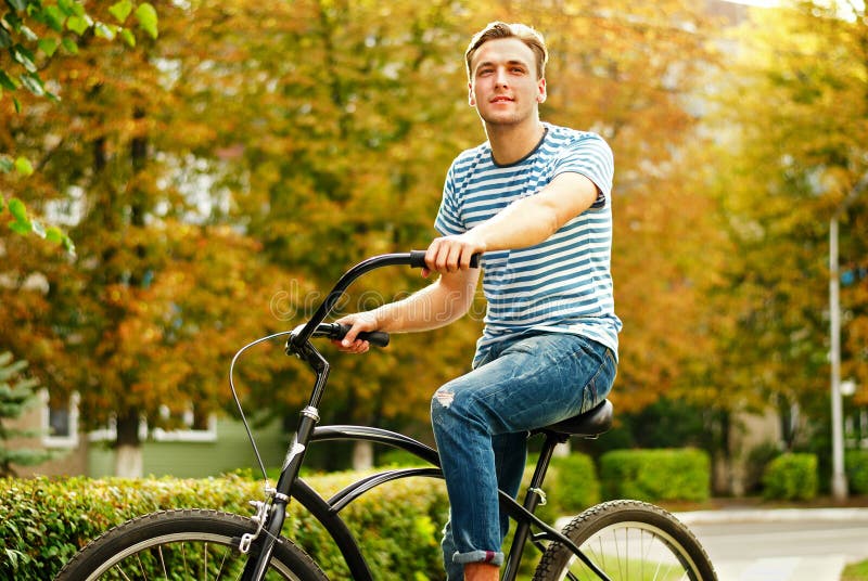 A young man on a bicycle looks into the distance