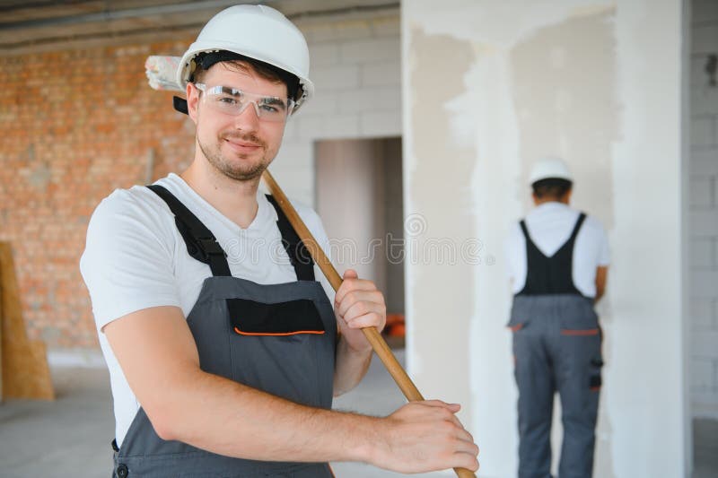 Young man builder wearing hardhat at construction site stock images