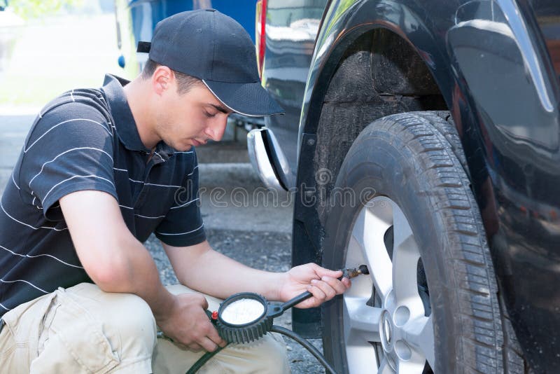 Young Man Checks the Tire Pressure of the Car Stock Photo Image of