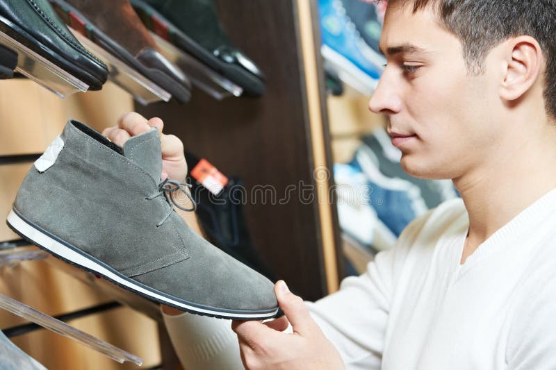 Young man choosing shoe in clothes royalty free stock image Young man choosing shoe in clothes royalty free stock image