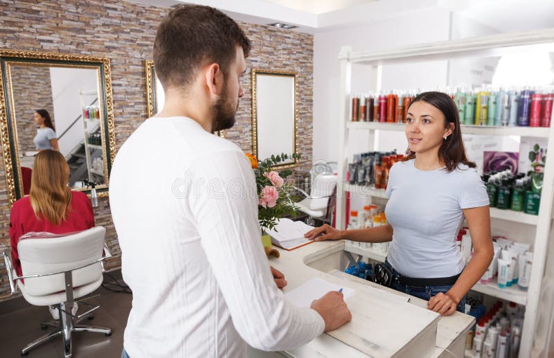 Young man client talking with woman assistant about services